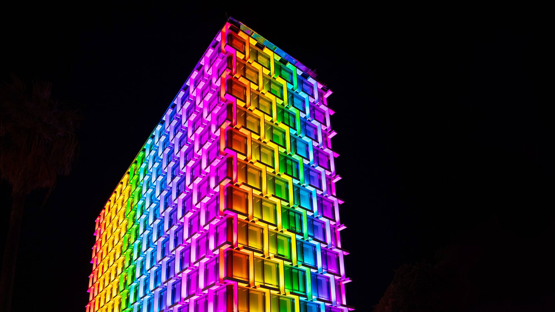 Latitude LED luminaire in application, installed on the facade on Council House in Perth. Colour changing feature is illustrated, the building is illuminated in rainbow colours. 