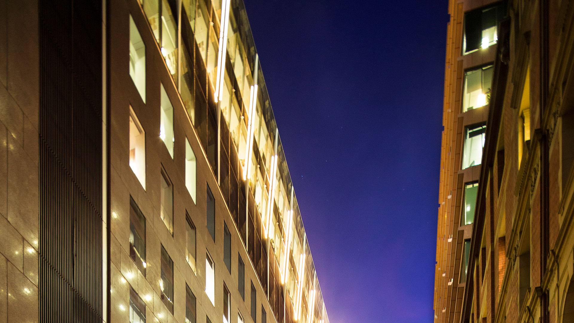 Illumination to the façade of the Holding Redlich Building in Bourke Street, Melbourne. 5-meter-long custom Beam was mounted as fin-like luminaries that point towards the glass, and are positioned all around the crown of the building.
