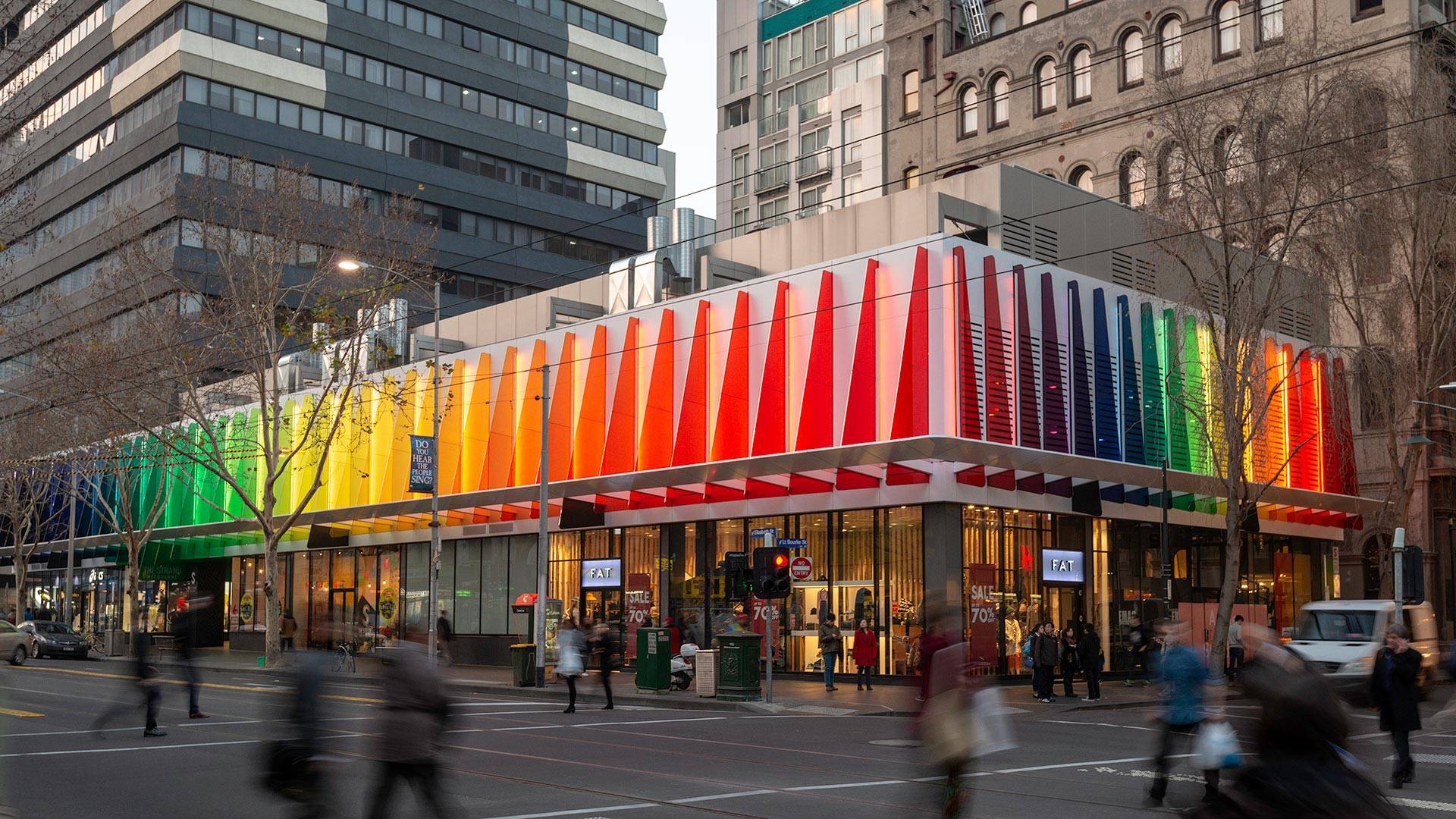 Maxis high-power linear flood light  in application, installed on the Strad Facade in Melbourne CBD. Every second coloured panel is illuminated by a Maxis high-power luminaire.