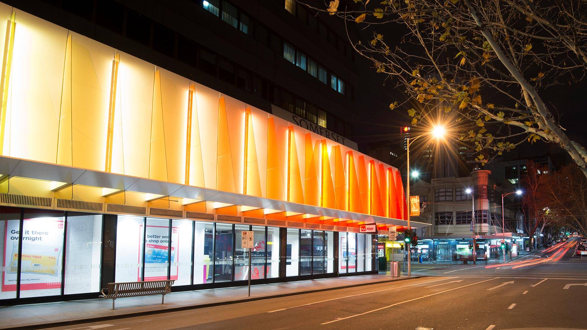 Maxis high-power linear flood light  in application, installed on the Strad Facade in Melbourne CBD. Every second coloured panel is illuminated by a Maxis high-power luminaire.