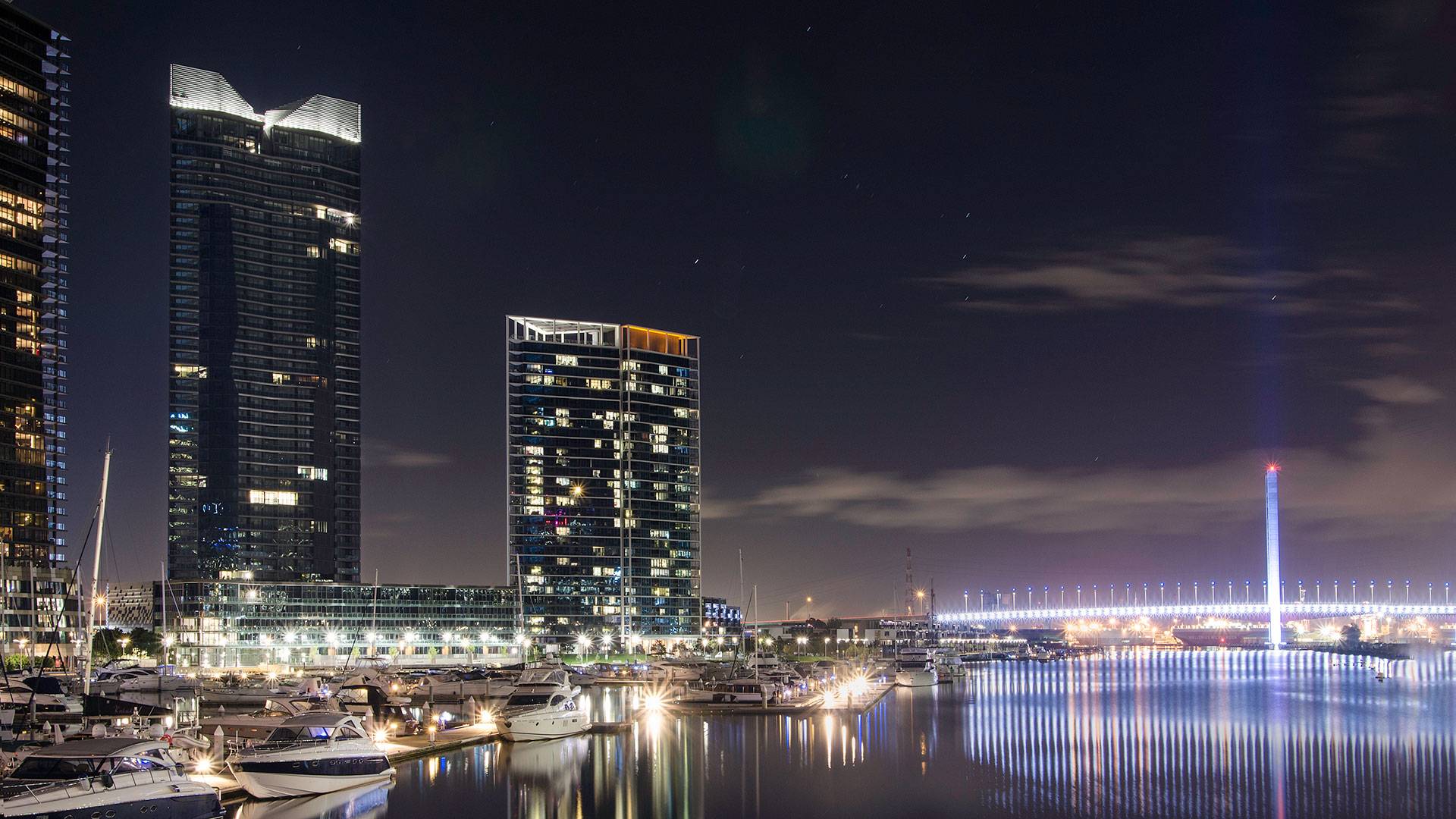Maxis high-power linear flood light  in application, installed on Yarra Point (Tower 6). Maxis high-powered projector luminaires, complete with flare optics, are used to illuminate the architectural crown of the building.