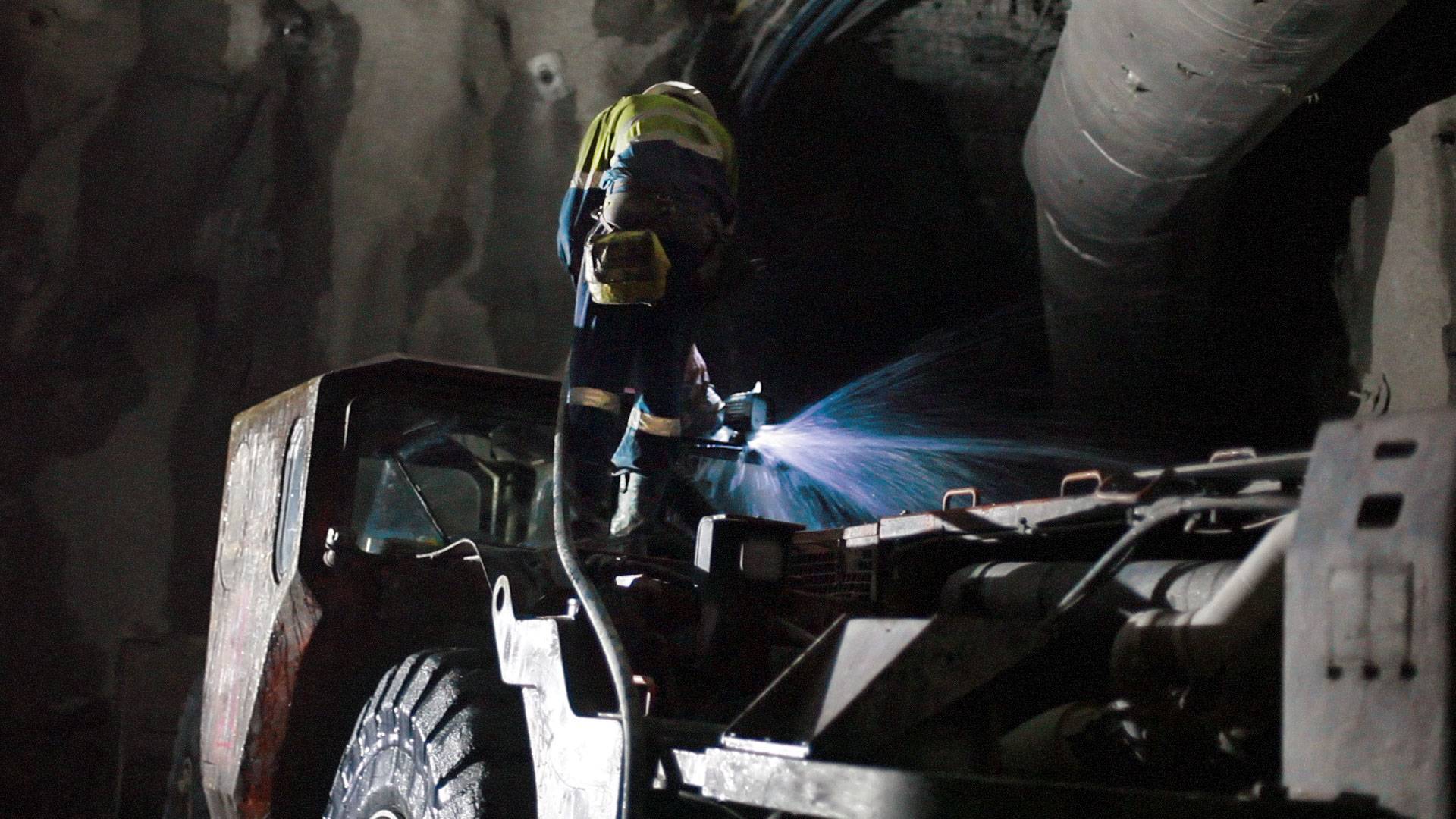CPUG Series LED Work Light in application, installed on an underground excavator and high-pressure washed by a mine site personnel  