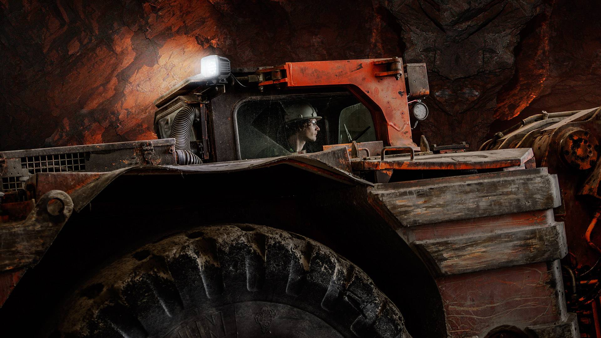 CPUG Series LED Work Light in application, installed on an underground excavator and high-pressure washed by a mine site personnel  