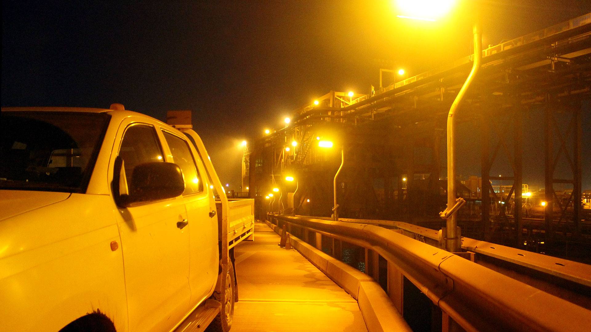 DLK2 LED Conveyor / Area Light in turtle-friendly amber colour temperature in application, installed in a bulk port in a fog